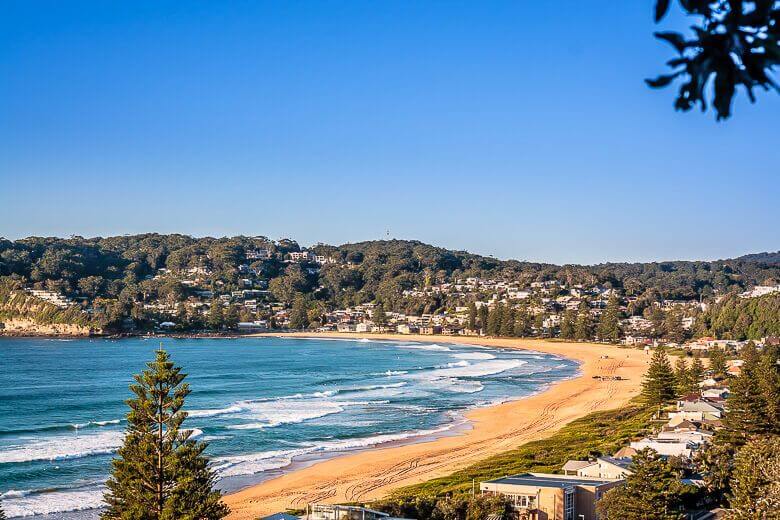 Aerial view of Avoca Beach with golden sand and rolling surf on the Central Coast