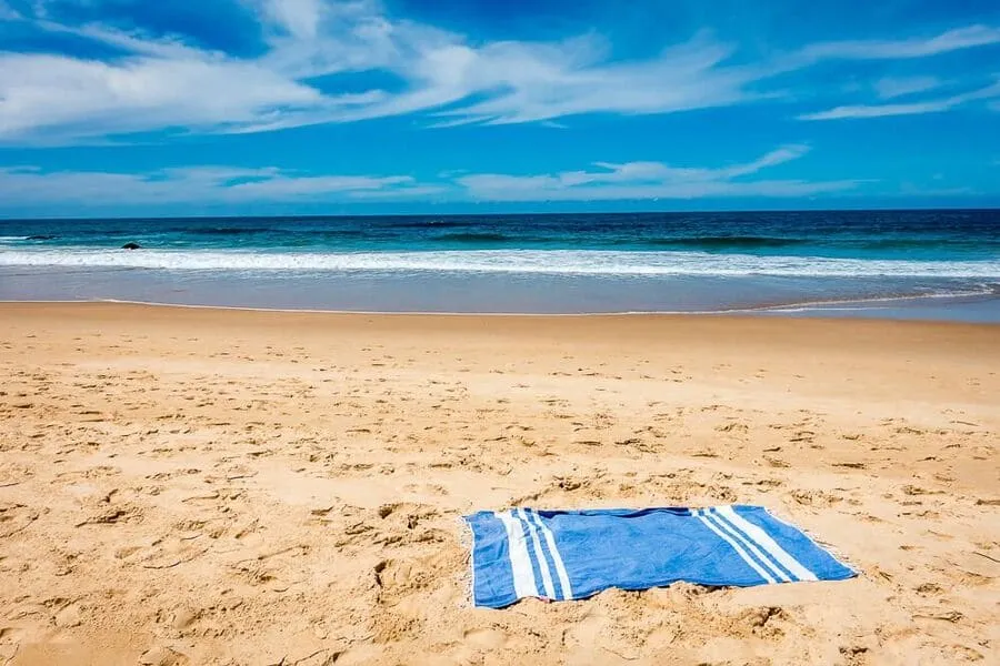 Blue beach towel on sandy beach Australia