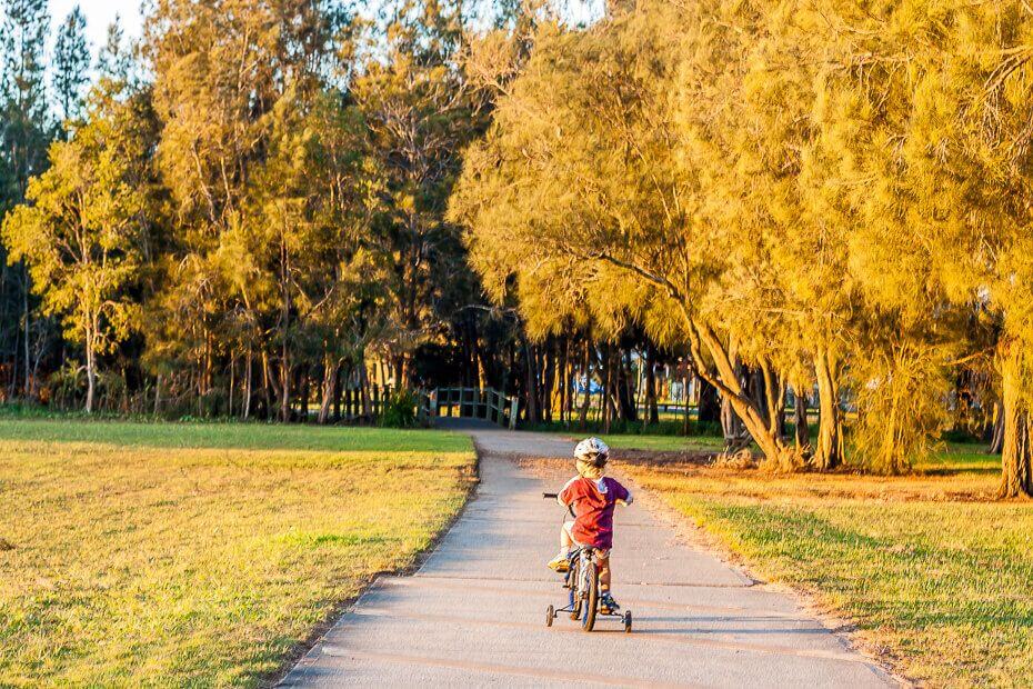 Child riding a bike along Tuggerah Lakes Cycleway at The Entrance