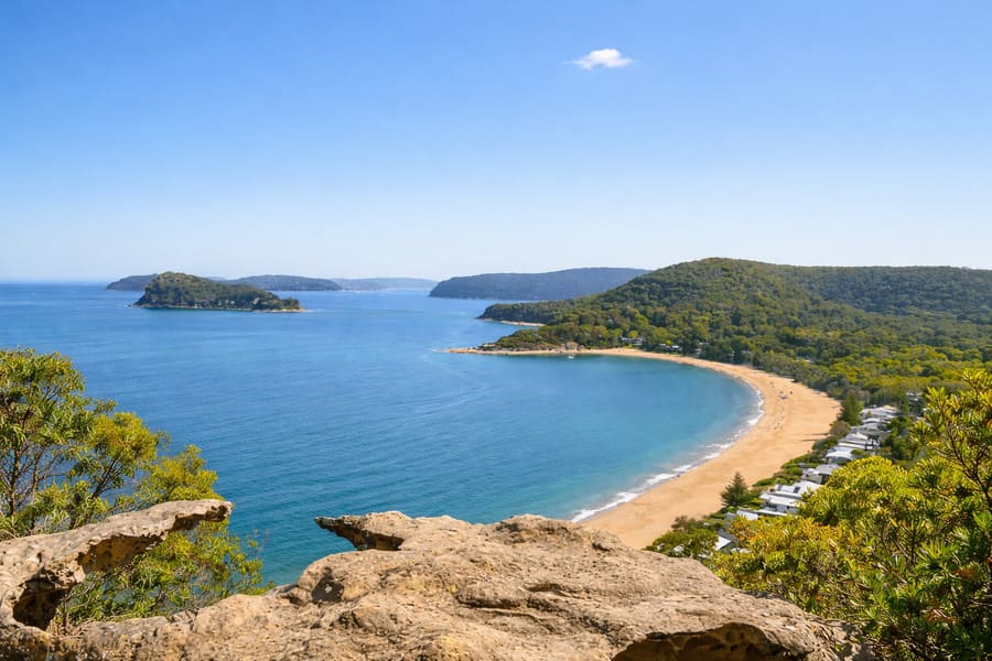 Elevated view of Pearl Beach on the Central Coast NSW with curved shoreline and bushland