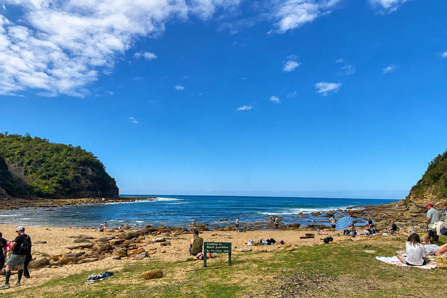 Visitors picnicking beside Little Beach in Bouddi National Park.