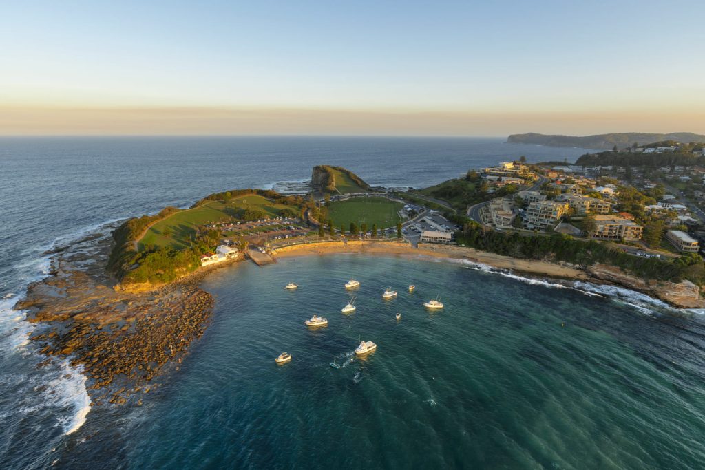 Aerial view of Terrigal Haven, The Skillion and anchored boats at sunset on the Central Coast of New South Wales.