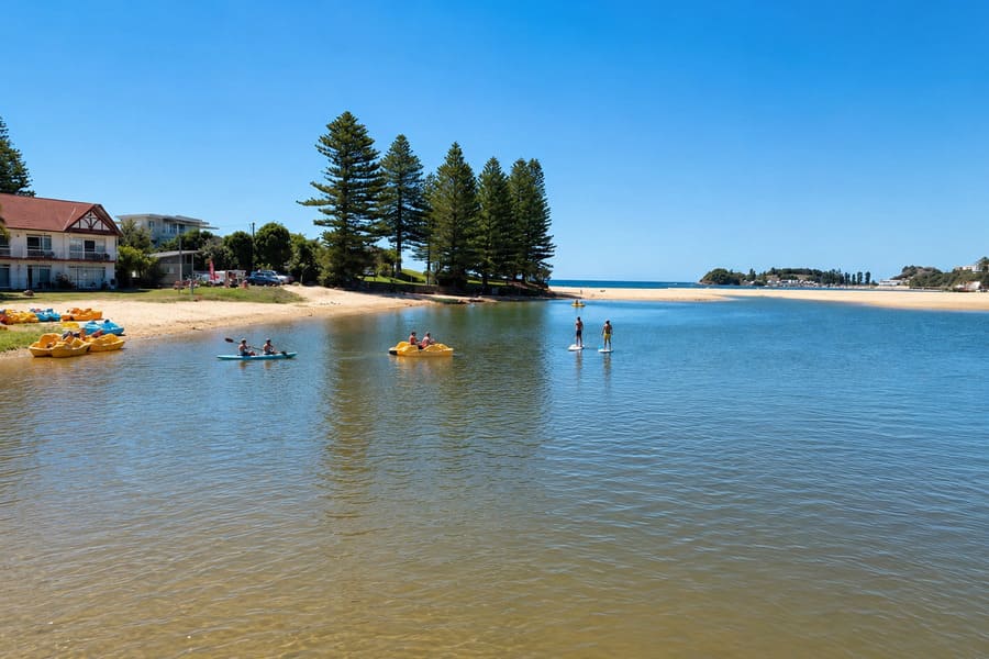 People paddleboarding, kayaking and pedalling on Terrigal Lagoon near Terrigal Beach on the Central Coast of New South Wales.