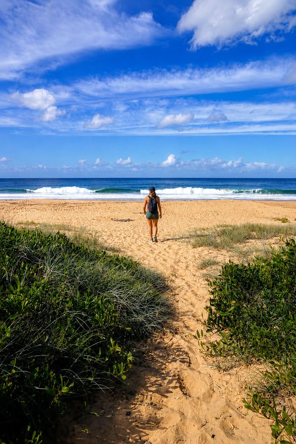 Walker approaching Tallow Beach in Bouddi National Park.