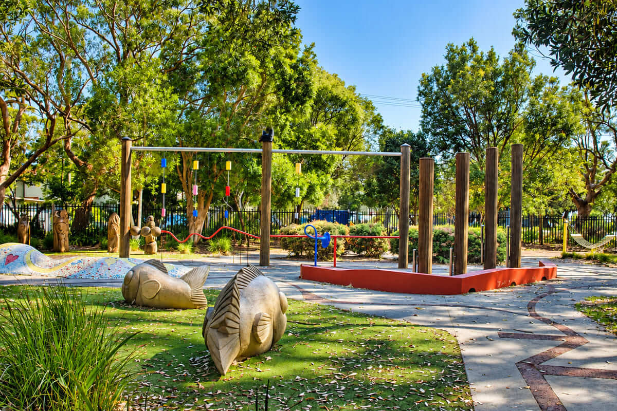 Canton Beach playground with wooden fish sculptures and balance beams