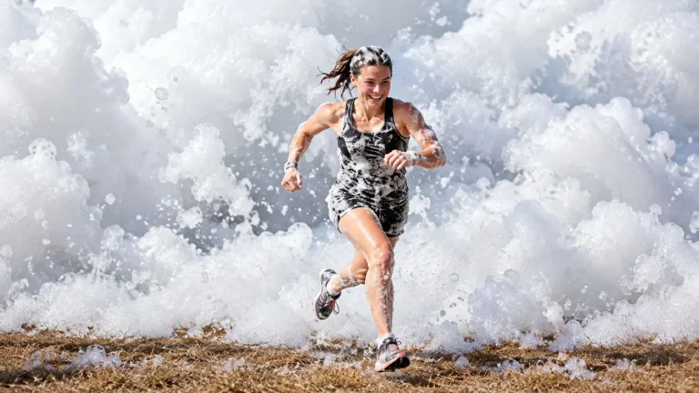 woman running through thick white foam obstacle course 768x432
