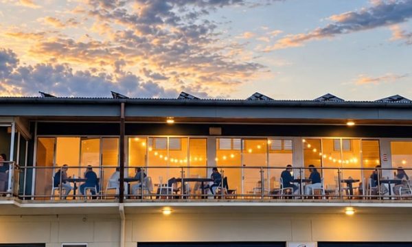 Diners seated on the upstairs balcony at Dunes by Dish in Norah Head at sunset