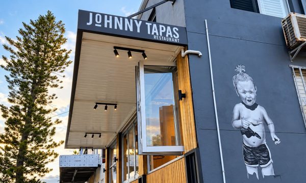 Exterior of Johnny Tapas restaurant in Norah Head with its wall mural and entrance