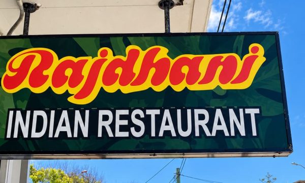 Exterior entrance of Rajdhani Indian Restaurant in Wamberal with the restaurant sign above the doorway