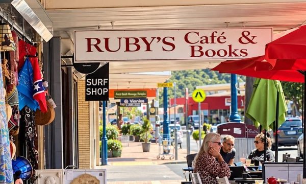 Ruby’s Café & Books with red umbrellas and outdoor seating along the shopping strip
