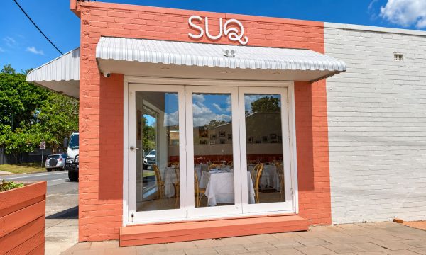 SUQ restaurant in Wamberal with a coral and white exterior, striped awning and front dining room window